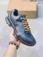 Angled side view of a dark ECCO BIOM sneaker highlighting the textured upper, padded collar and orange outsole accents.