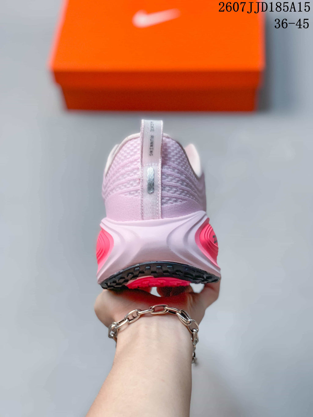 Rear view of the pale pink running shoes showing the padded heel area, pink accents, and black outsole.