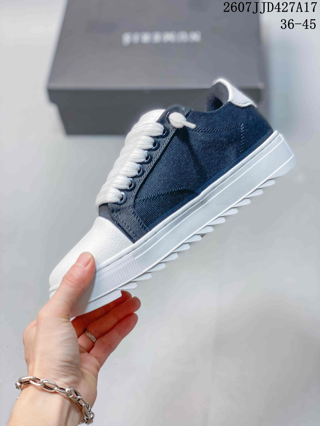 Side view of the sneaker showing the navy denim-style upper, white laces, white toe panel, and ridged outsole.