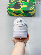Rear view of the white sneaker with STA branding and a camouflage A Bathing Ape shoebox.