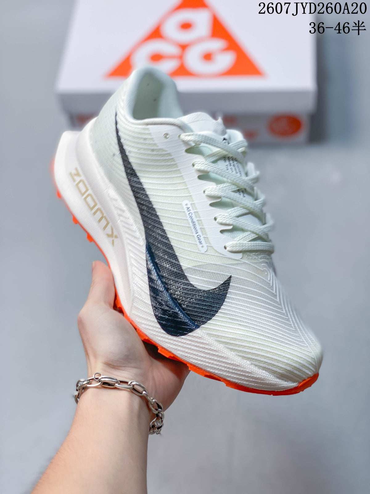 Angled close-up of an off-white Nike ACG Ultrafly Trail sneaker with black side branding and visible style code overlay.