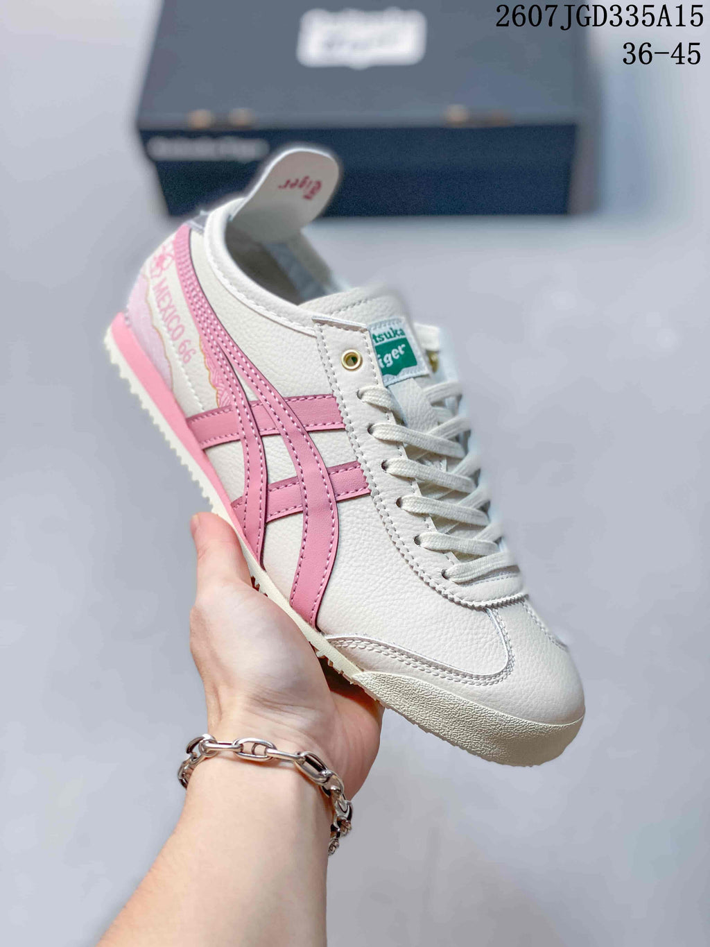 Close-up side view of a white and pink Onitsuka Tiger Mexico 66 Deluxe sneaker showing the side detailing, heel graphics, laces, and outsole.