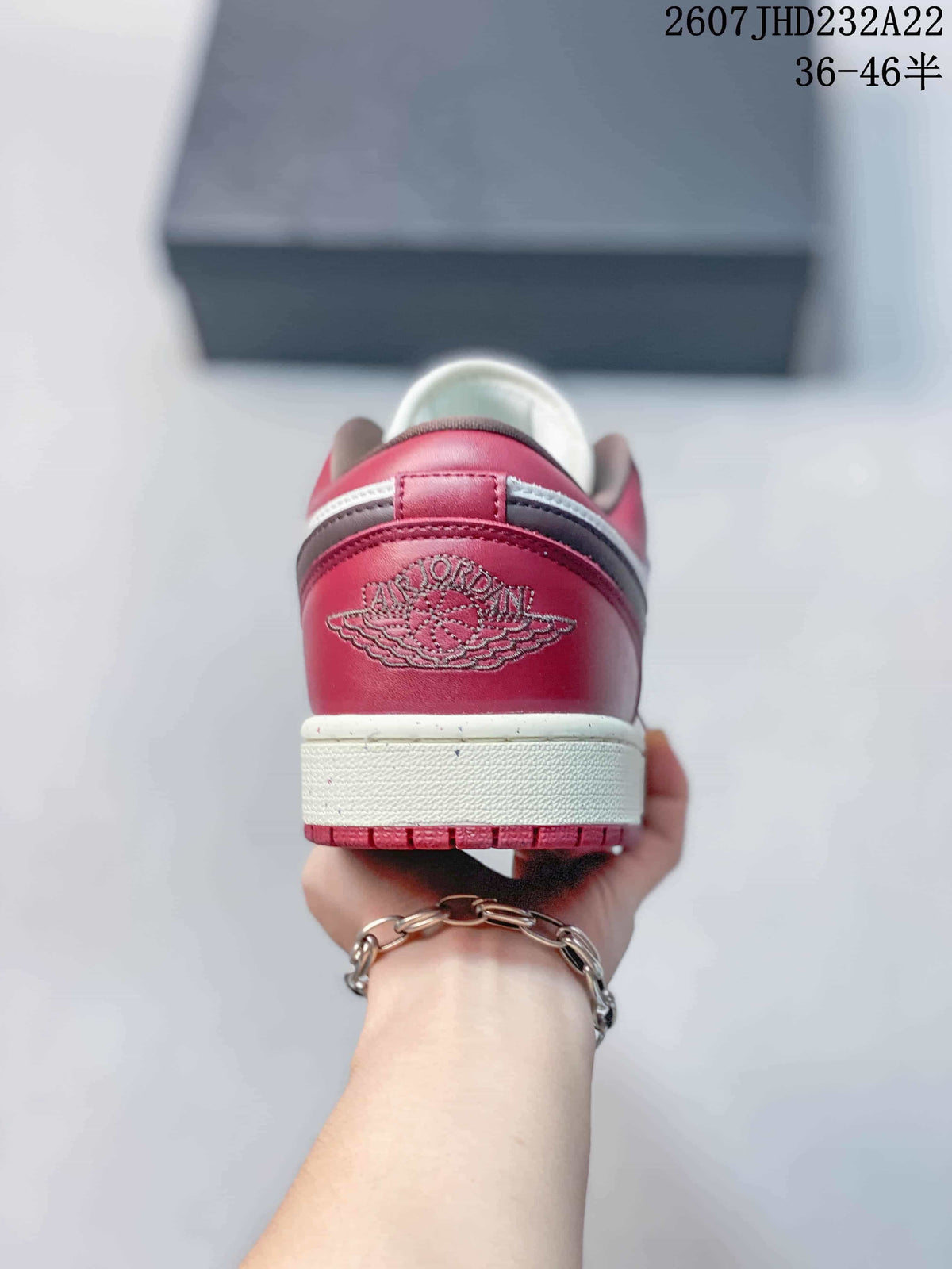 Rear view showing the red heel panel, winged emblem, white midsole, and red outsole.