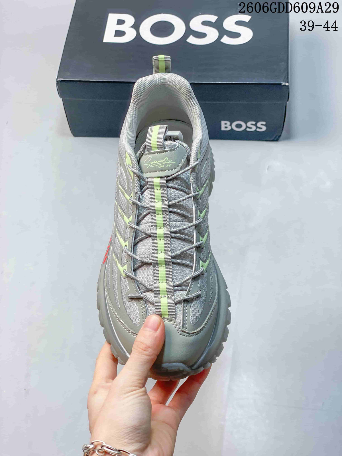 Front view of a grey BOSS sneaker with lace-up closure and lime details