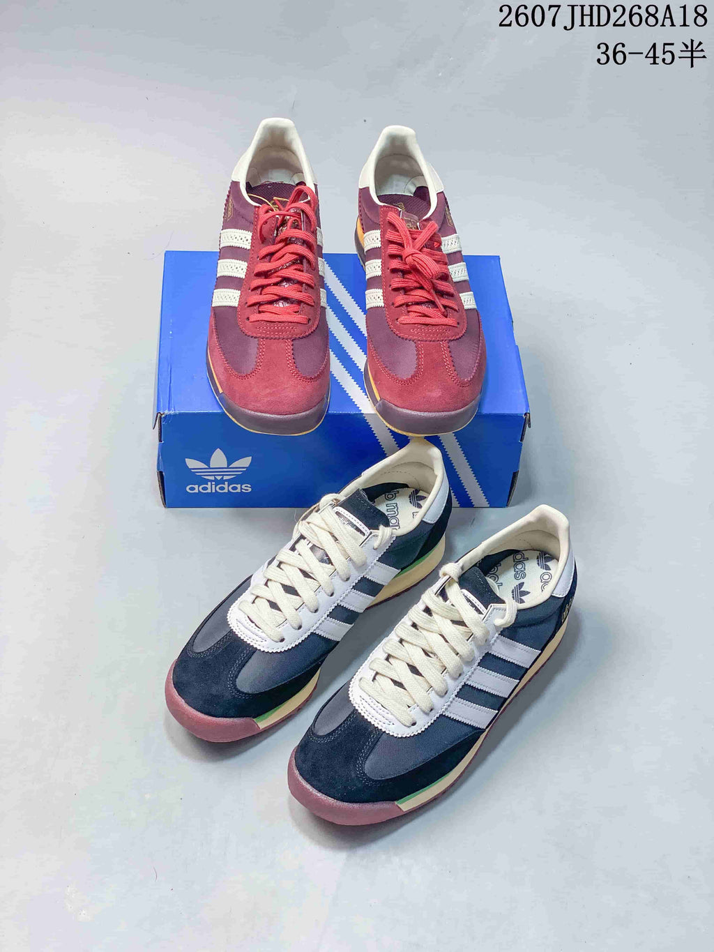 Burgundy and navy adidas SL 72 sneakers arranged together with a blue adidas shoebox.