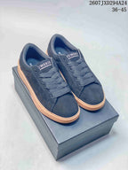 Pair of dark navy Numeris low-top sneakers with tonal laces and gum-colored platform soles displayed on a shoebox.