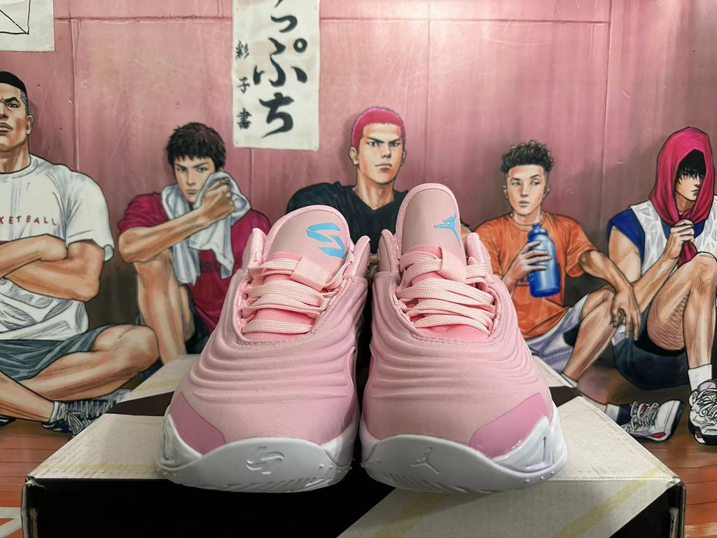 Front view of pink and white basketball shoes with turquoise tongue details