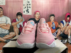 Front view of pink and white basketball shoes with turquoise tongue details