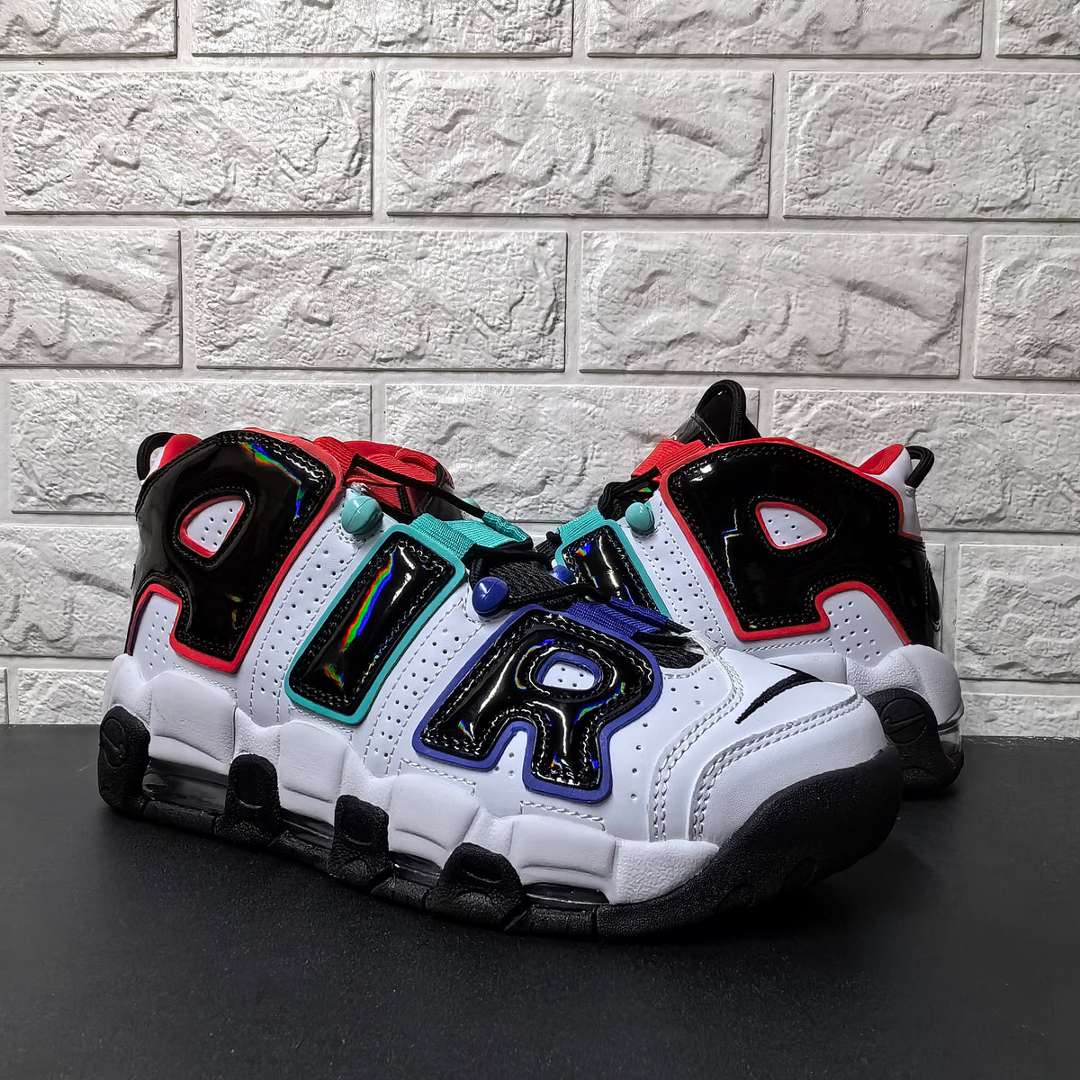 Pair of white and black high-top sneakers with colorful AIR lettering