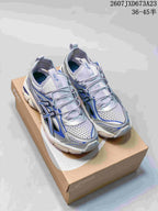 Pair of silver and blue ASICS Gel-Kayano 14 sneakers displayed on an ASICS shoebox; image text shows style code 2607JXD673A23 and size range 36–45.