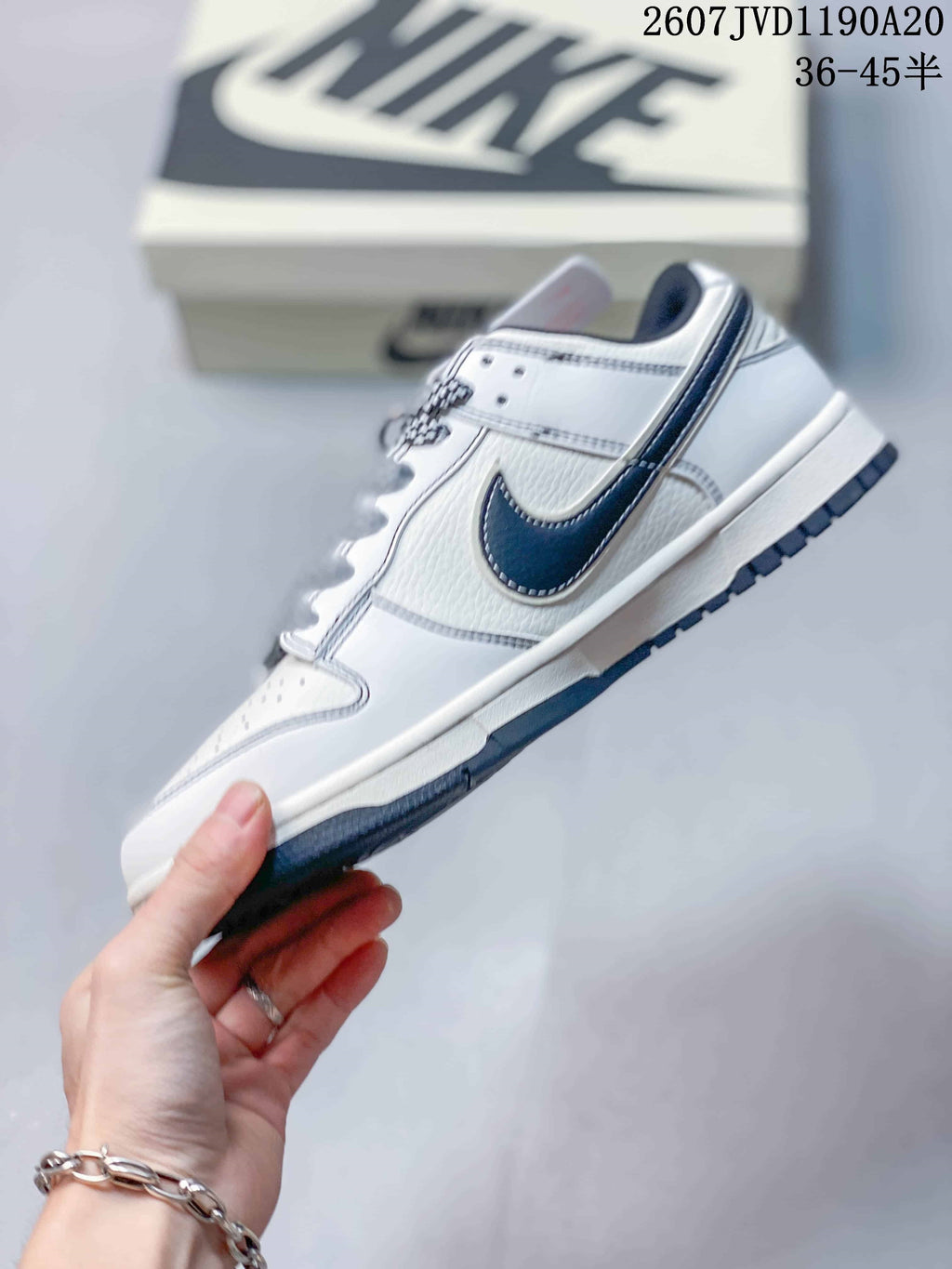 Side profile highlighting the off-white upper, dark Swoosh, patterned laces, layered panels, and low-top shape.