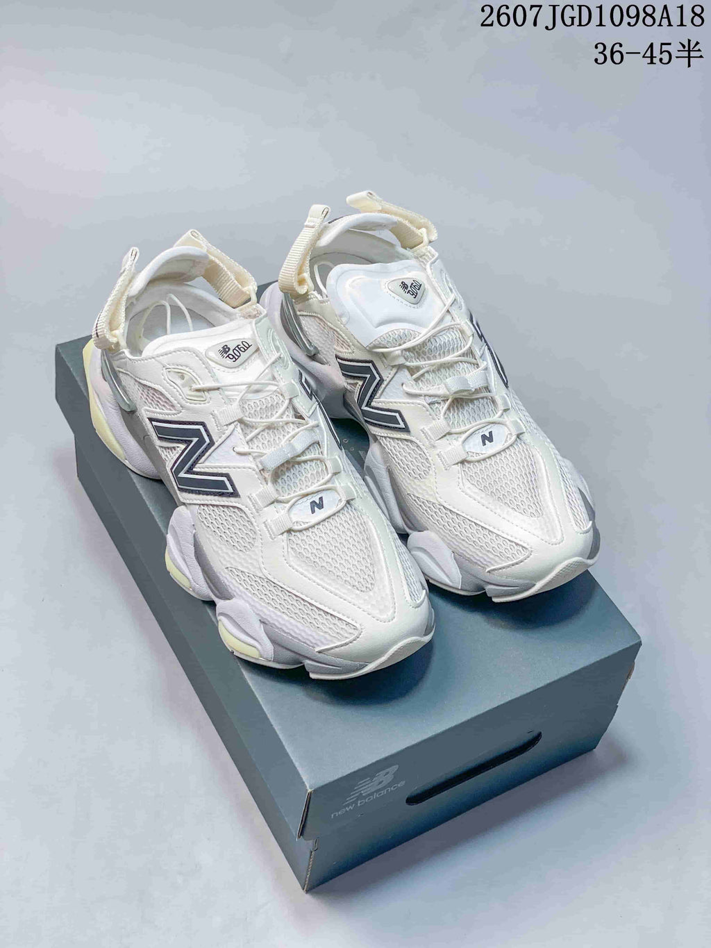 Pair of white and light grey New Balance 9060 sneakers displayed on a New Balance shoebox; overlay text shows style code 2607JGD1098A18 and size range 36–45 with half sizes.