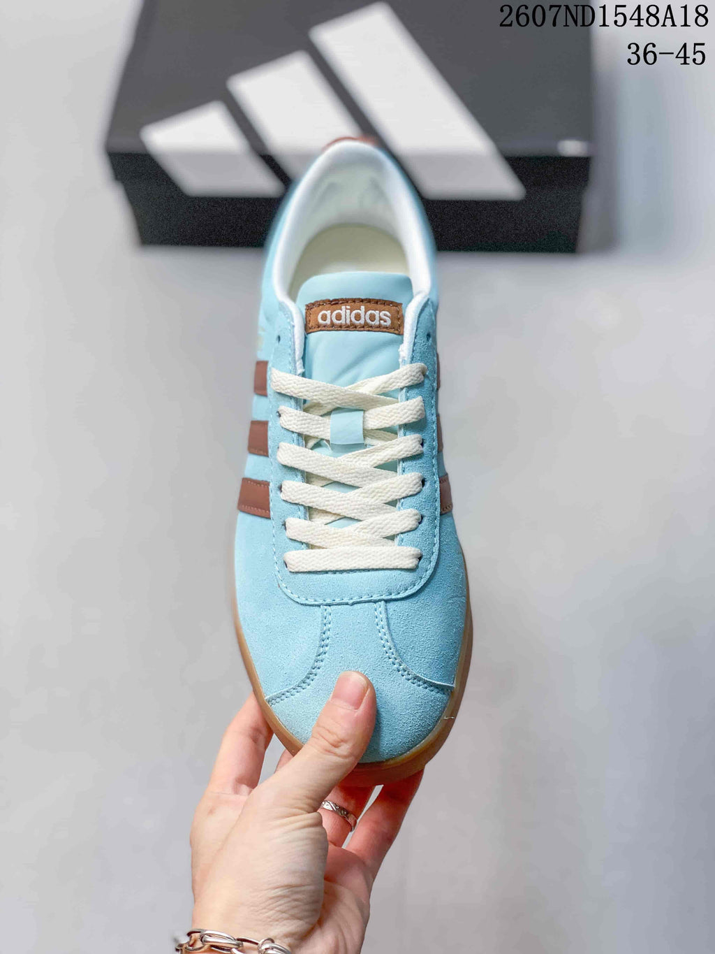 Top view of the light blue lace-up sneaker with cream laces and brown side detailing.