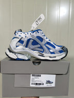 Side view of the white and blue Runner sneaker displayed on its shoebox, with the box label and style information visible.