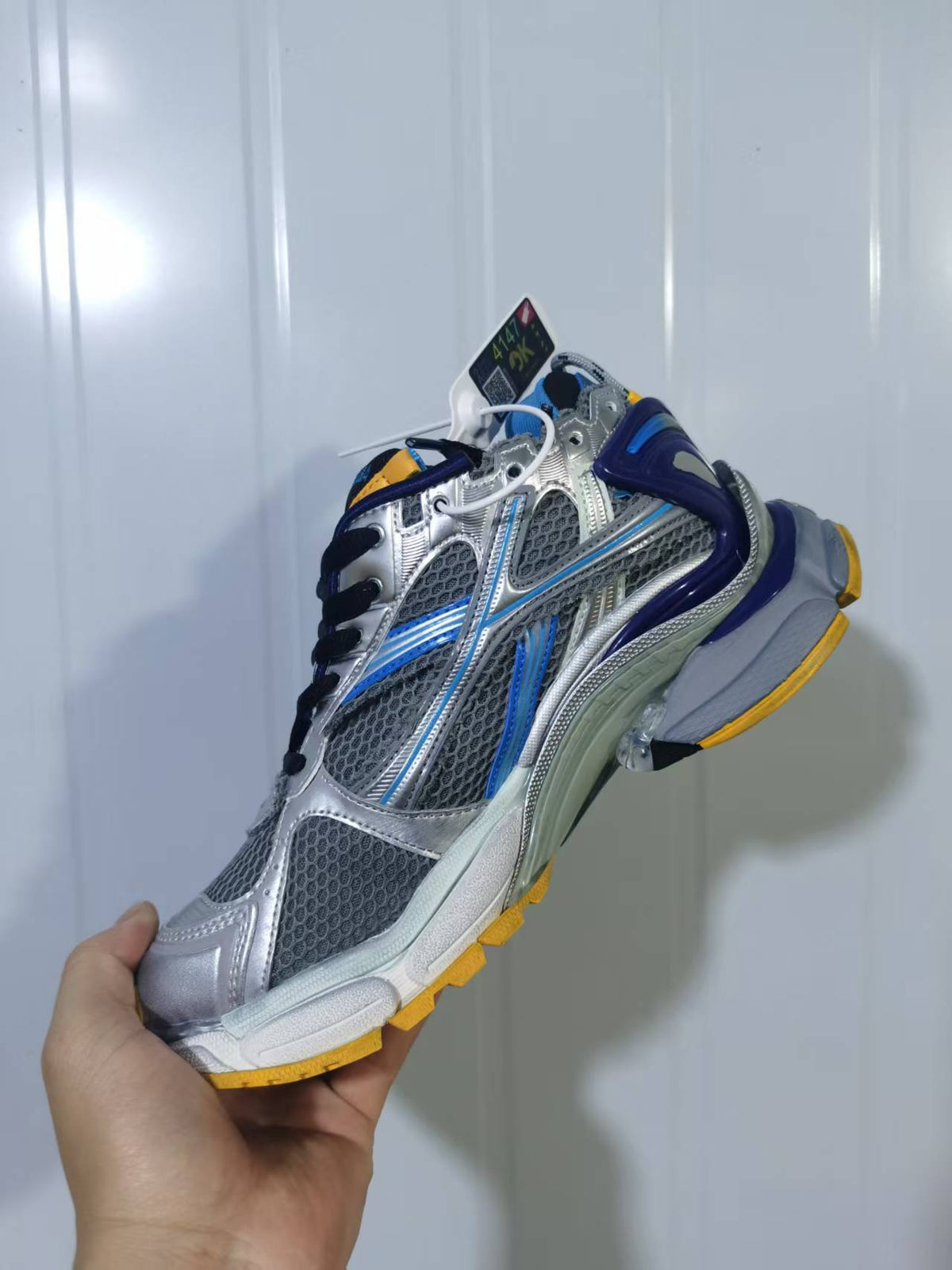Top and lateral view of the 1474 runner sneaker showing the mesh upper, dark blue details and textured tread.