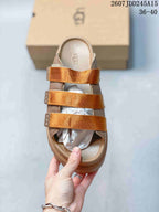 Top view of the tan open-toe sandal with three metallic-gold straps and padded footbed.