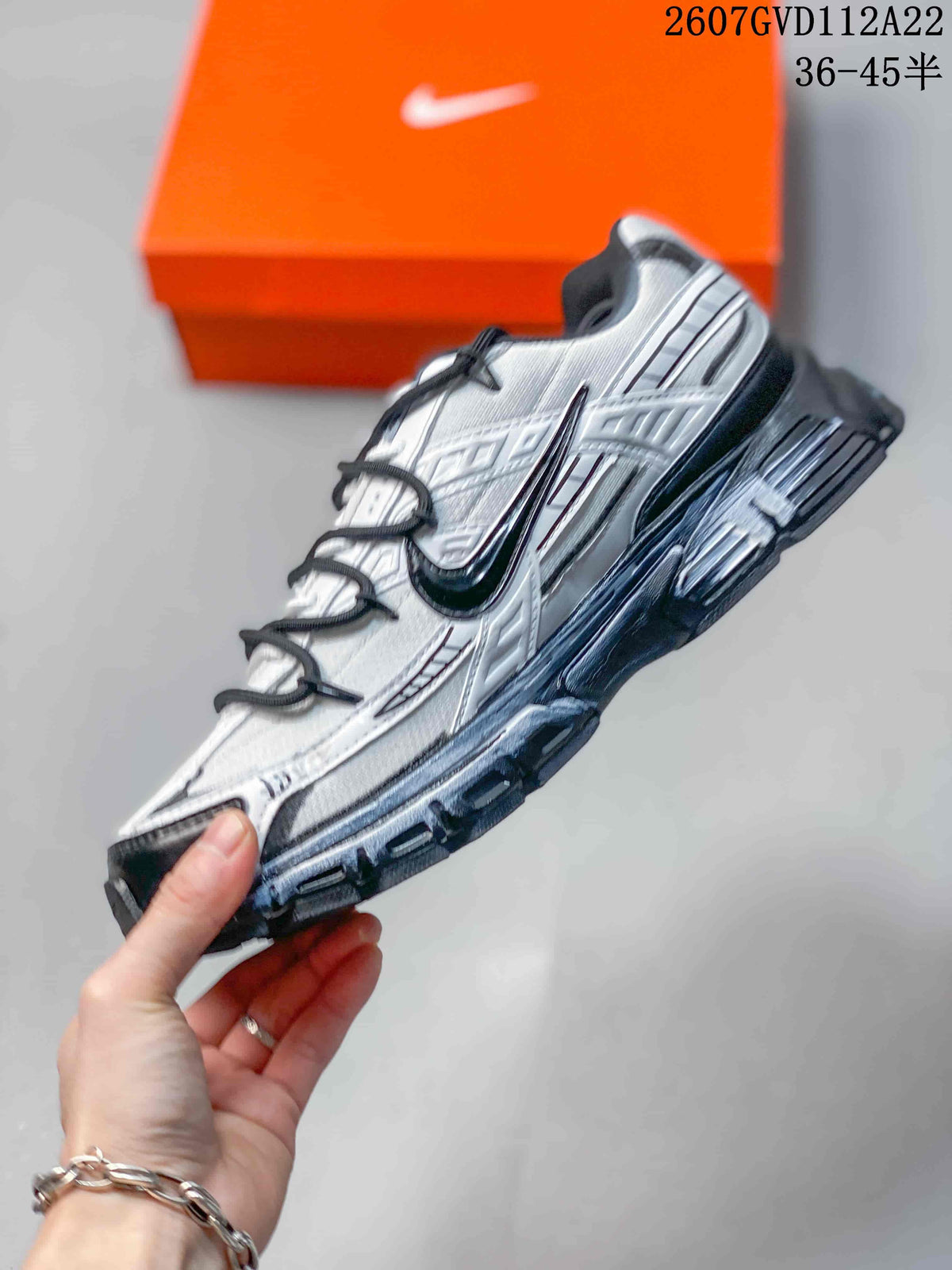 Side view of the sneaker showing layered upper panels, a large Nike Swoosh, dark trim, and a raised outsole.