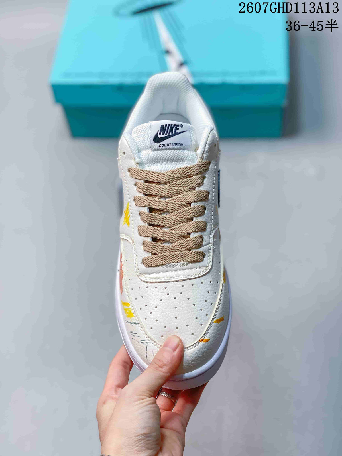 Top view showing the perforated white toe box, beige laces, tongue branding, and colorful painted accents.