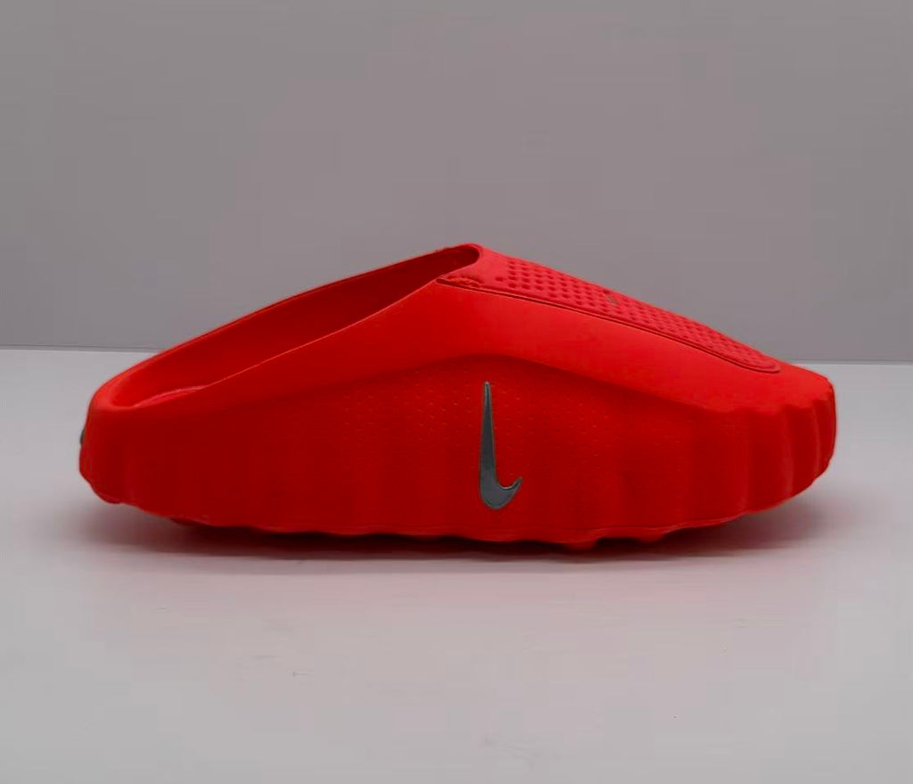 Side view of an orange-red Nike slide showing the raised sole and side Swoosh.