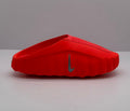 Side view of an orange-red Nike slide showing the raised sole and side Swoosh.