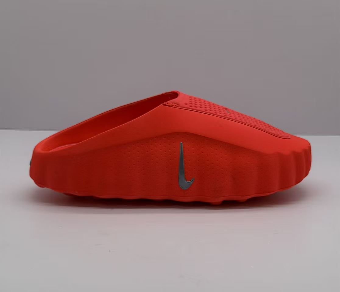 Side view of an orange-red Nike slide showing the raised sole and side Swoosh.