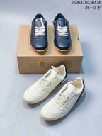 Navy and white colorways of low-top lace-up sneakers shown together.