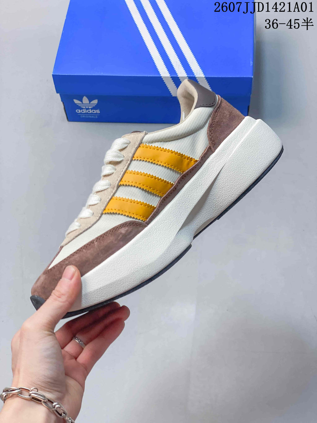 Side view of the sneaker with yellow stripes and a thick white sole