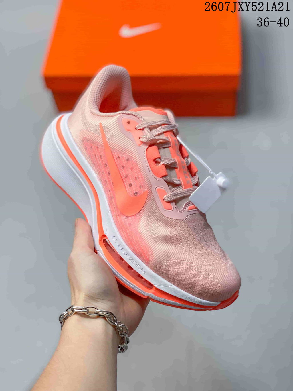 Angled side view of a pale pink and coral Nike sneaker showing the side branding, white midsole, and coral outsole.