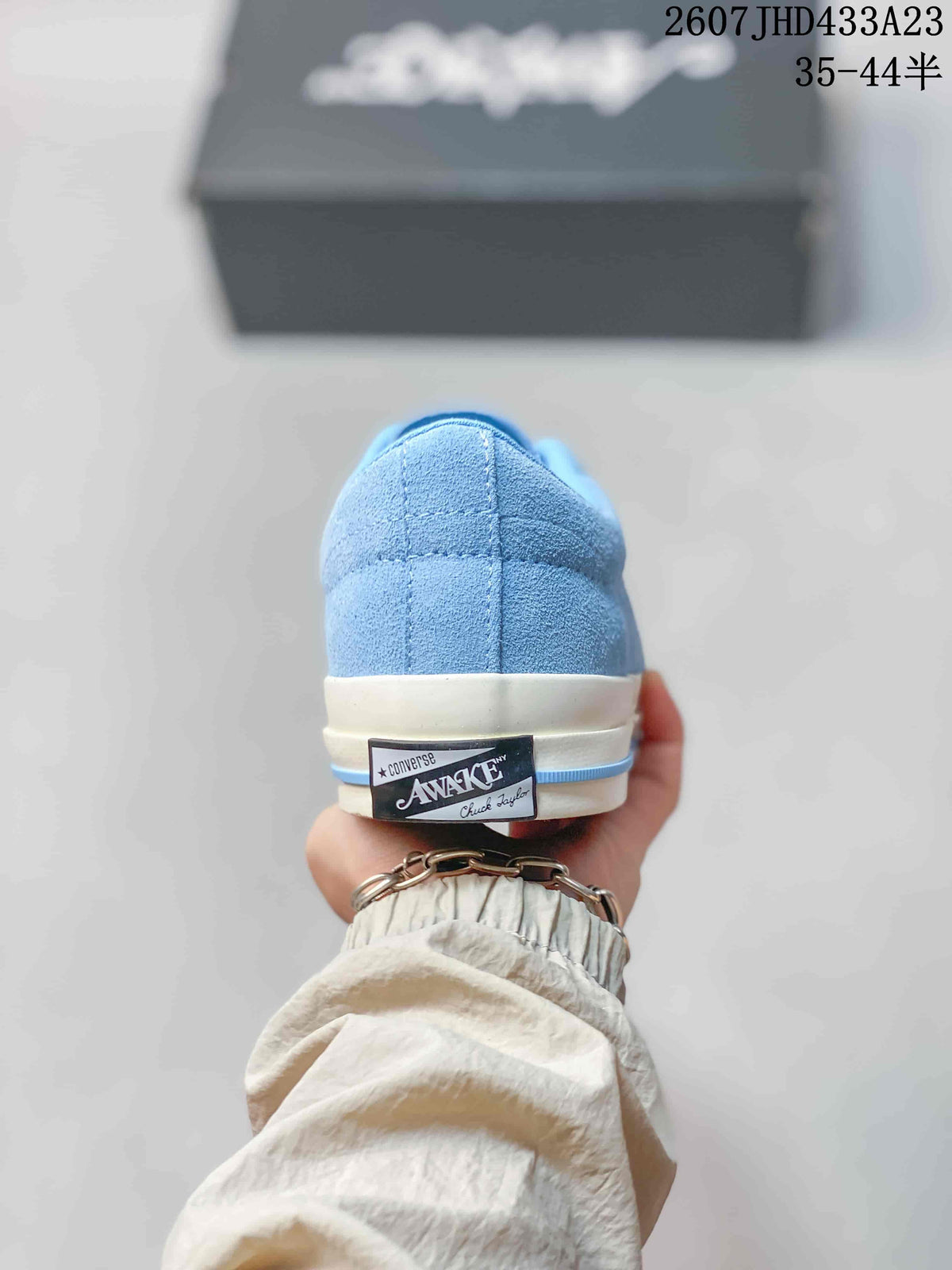Rear view of the light blue sneaker showing the heel label and off-white rubber sole.