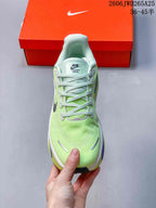 Front view of a lime-green Nike Vomero Premium shoe with pale mint laces.