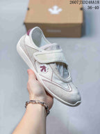 Angled side view of the white sneaker showing the strap closure, stitched overlays, and side emblem; the image shows the code 2607JXD248A18 and size range 36–40.