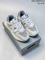 Pair of grey and off-white New Balance 5740 sneakers displayed on a shoebox.