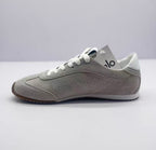 Opposite side view of the gray lace-up sneaker with perforated side detailing.