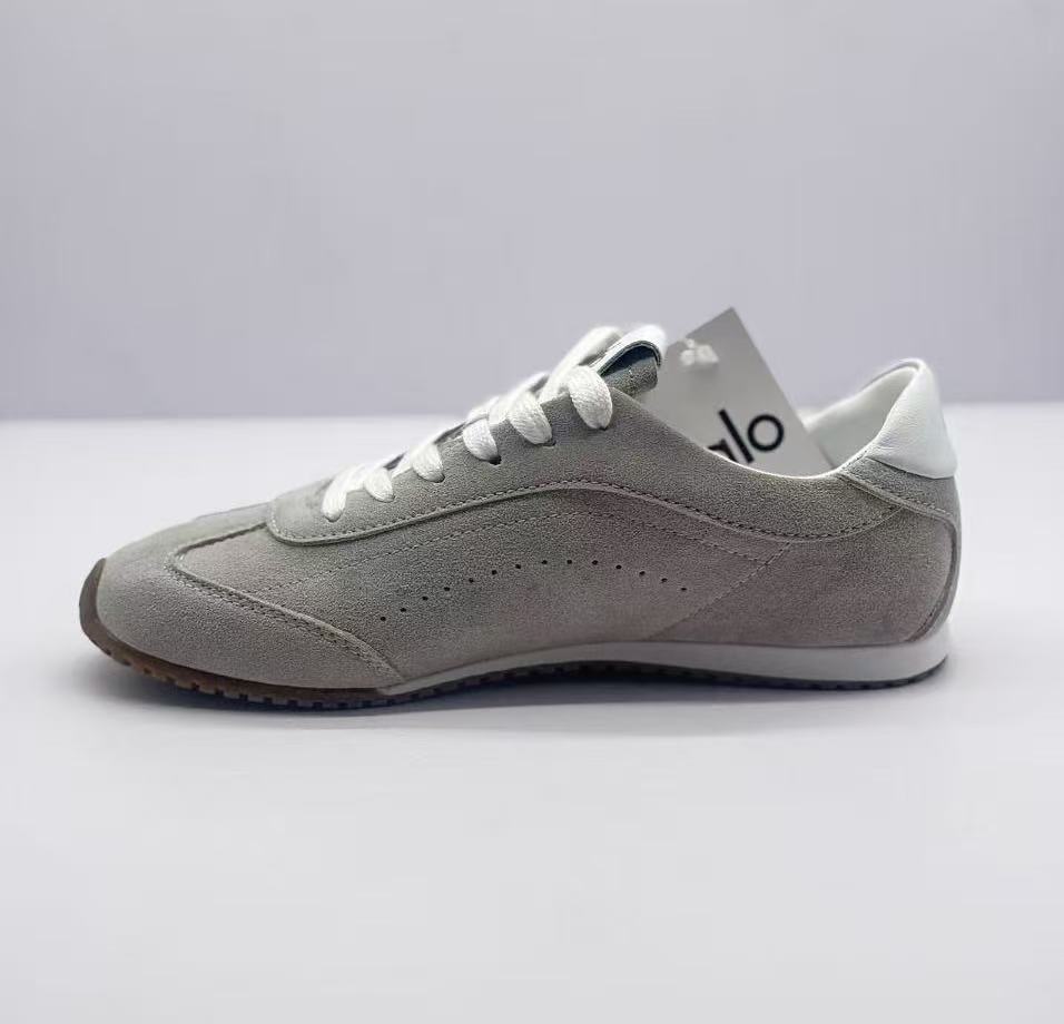 Opposite side view of the gray lace-up sneaker with perforated side detailing.