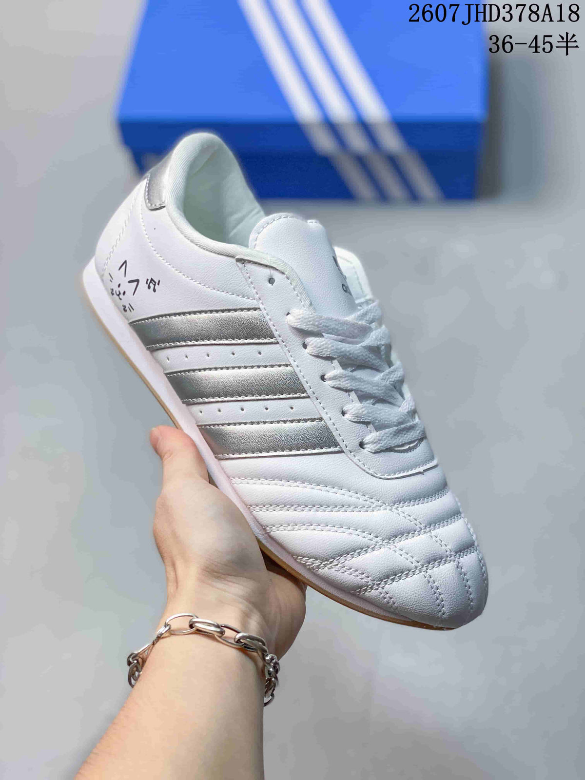 Side view of a white adidas sneaker showing the dark side stripes, lace-up front, padded collar and gum-colored outsole.
