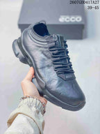 Angled side view of the dark ECCO sneaker showing the lace-up construction, padded collar, and patterned sole.