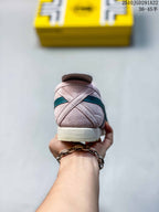 Rear view of the pink sneaker showing stitched heel panels, teal side detailing and a light cream heel section.