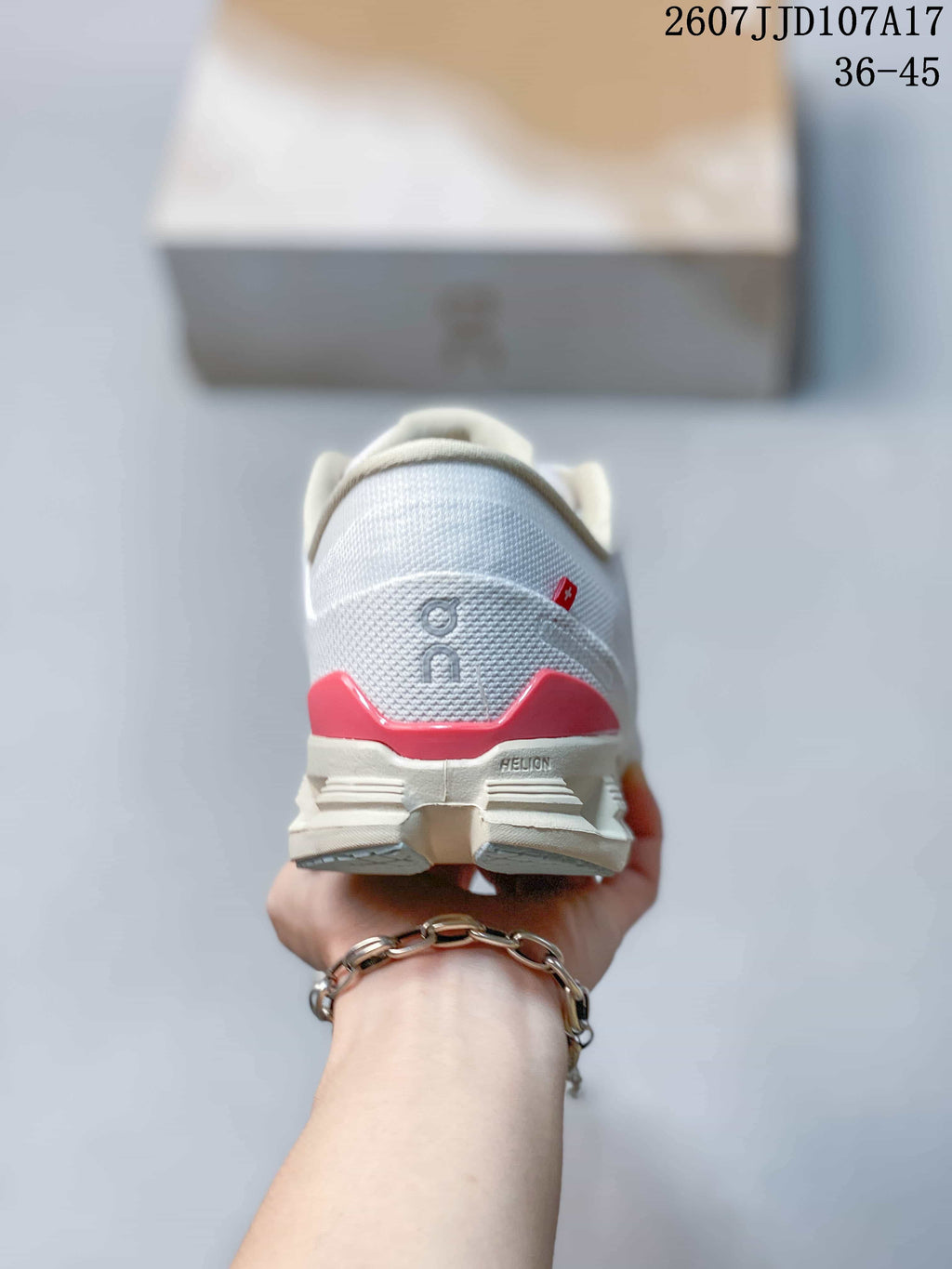 Rear view of the white sneaker showing the On logo, red heel accent and Helion marking on the midsole.
