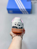 Rear view of the sneaker showing the cow-print heel, pink collar lining and gum-colored heel section.