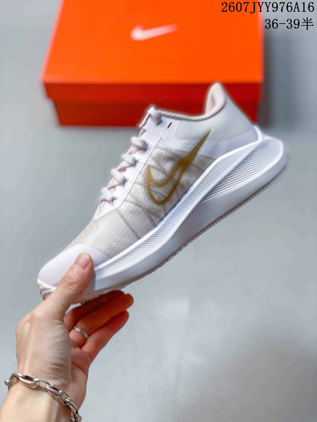 Side profile of the white and gold low-top sneaker with its textured midsole and lace-up design.
