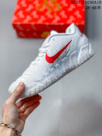 Side profile showing the red Swoosh, white upper and textured outsole.