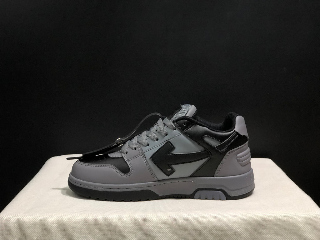 Side profile of one grey and black sneaker showing the layered upper and dark outsole.
