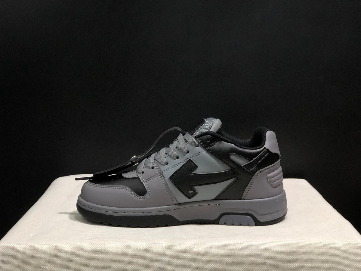Side profile of one grey and black sneaker showing the layered upper and dark outsole.
