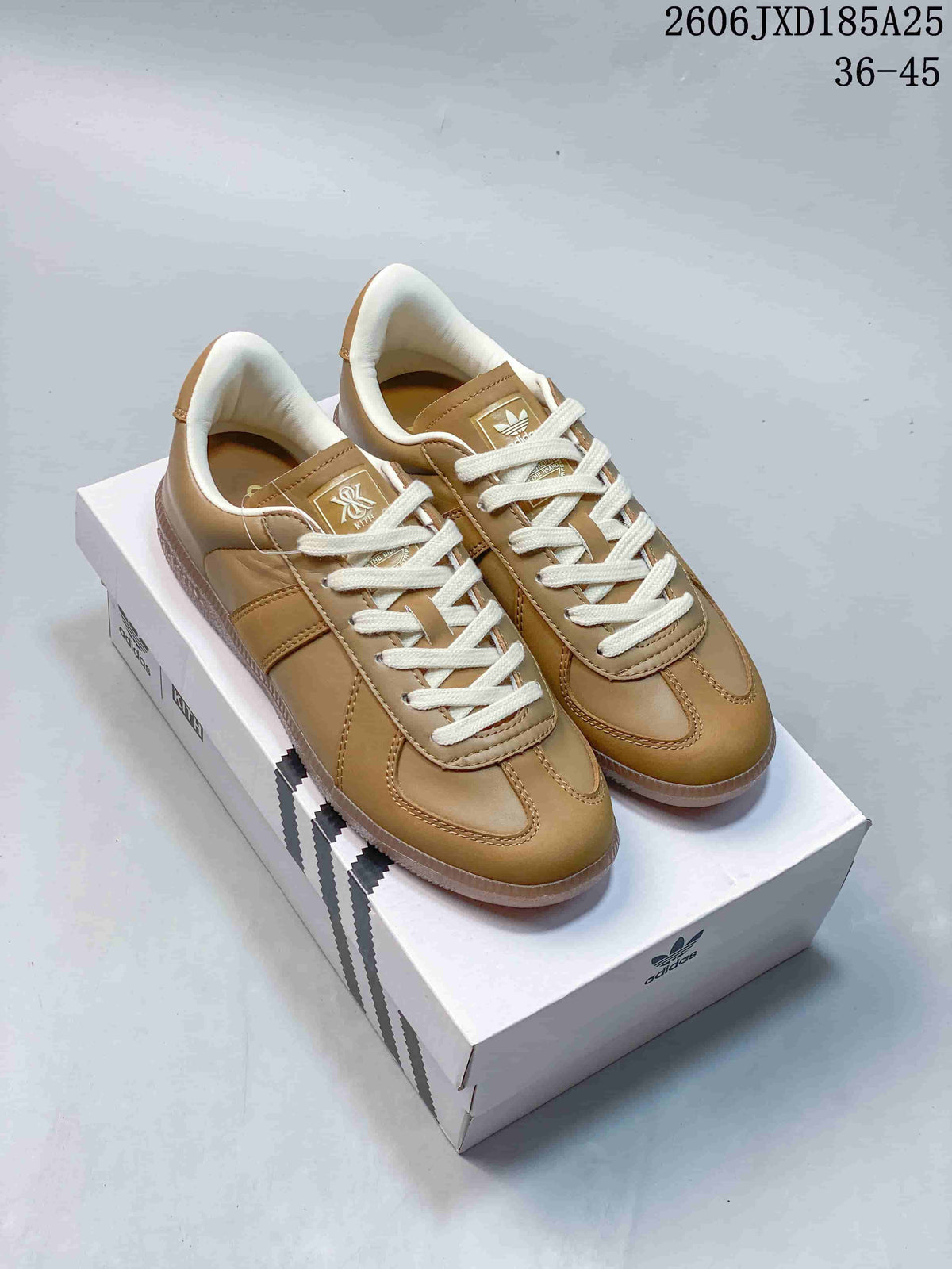 Pair of tan adidas BW Army sneakers with cream laces on a shoebox