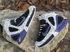 Top and side view of the high-top pair with ankle straps and purple-blue heel accents