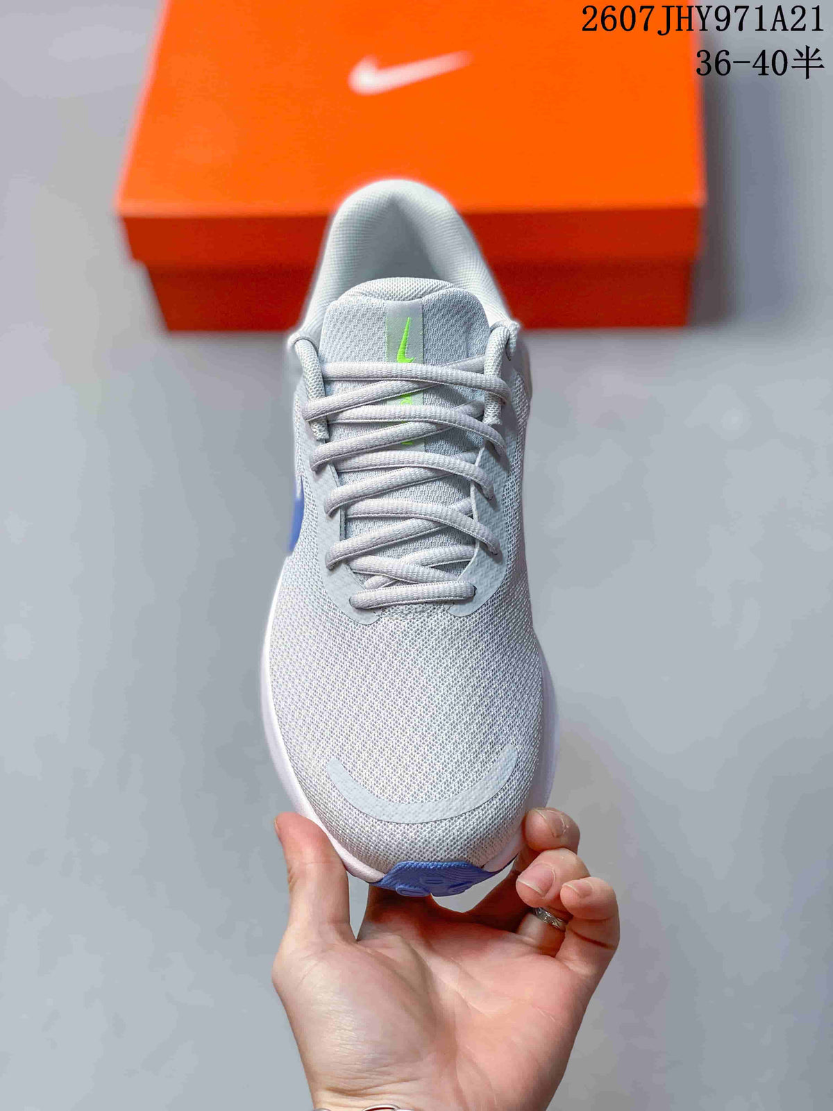 Top view of a light gray Nike running shoe showing the lace-up closure, textured upper, and small green tongue accent.