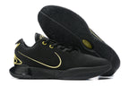 Black Nike basketball shoes with gold detailing and black outsoles.