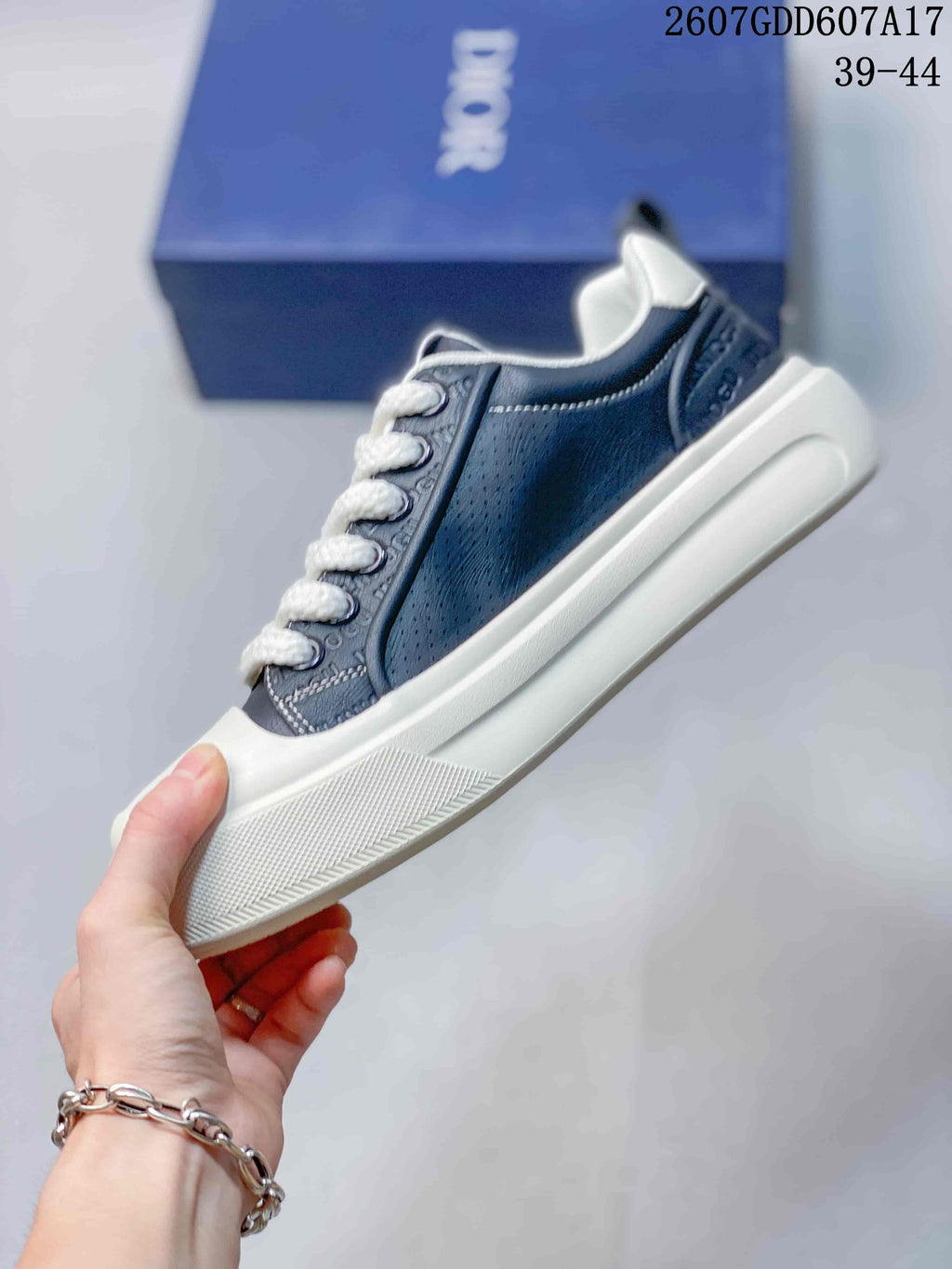 Side view showing the navy perforated upper, white laces, contrast stitching, and raised sole.