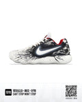 Side view of white low-top Nike basketball sneakers with black splatter-style graphics and red lining.