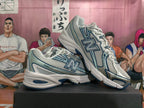 Angled side view of white and blue New Balance sneakers